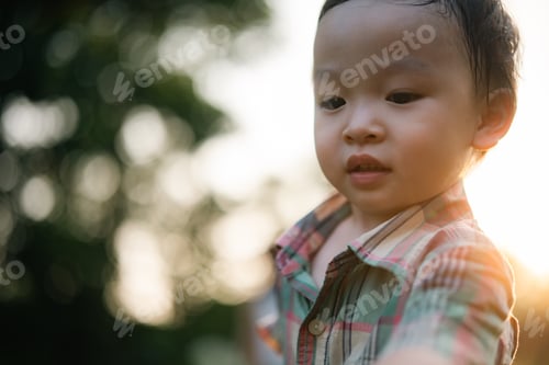 Preview: Adorable young boy enjoying outdoor sunshine with happy expression and natural bokeh