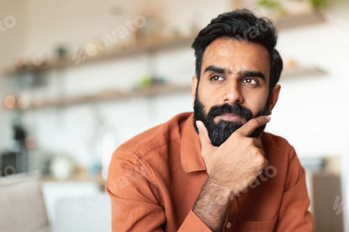 Preview: Portrait Of Pensive Young Arabic Man Thinking In Living Room