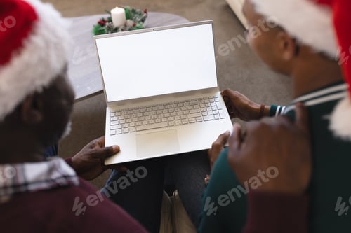 Preview: African american father and son having christmas laptop video call, copy space screen