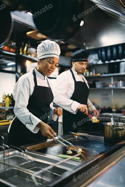 Preview: Two restaurant chefs preparing food in the kitchen.