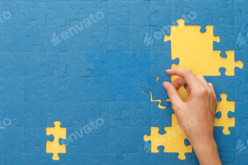 Preview: cropped view of woman matching blue jigsaw puzzle on yellow background