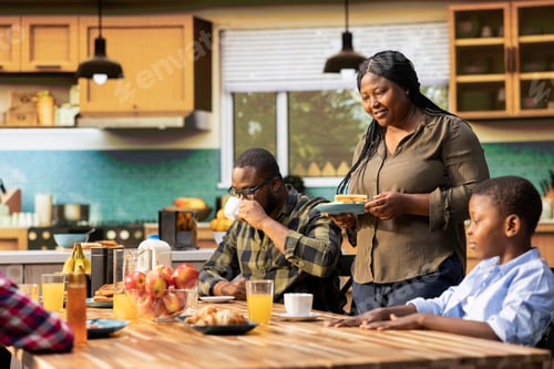 Preview: Smiling mother serving her kids and husband with bacon and eggs