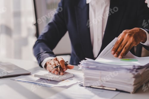 Preview: work from office A businessman works a bunch of paper files to find information on his desk at home.