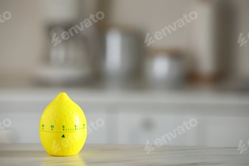 Preview: Kitchen timer in shape of lemon on white marble table against blurred background. Space for text