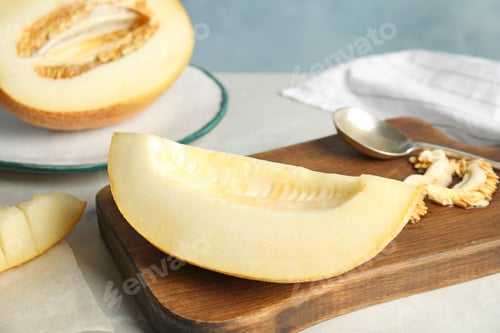 Preview: Wooden board with tasty cut ripe melon on table