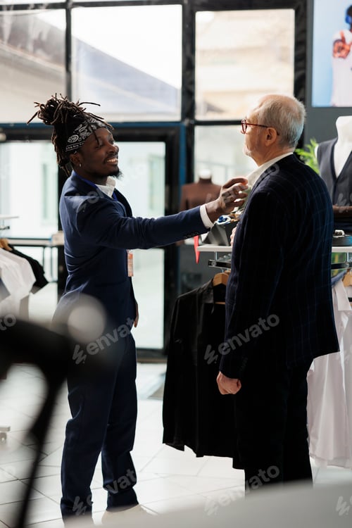 Preview: Store worker helping stylish customer choosing formal suit