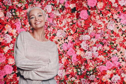Preview: Pretty young woman spring portrait dressed with pink blossoming flowers.