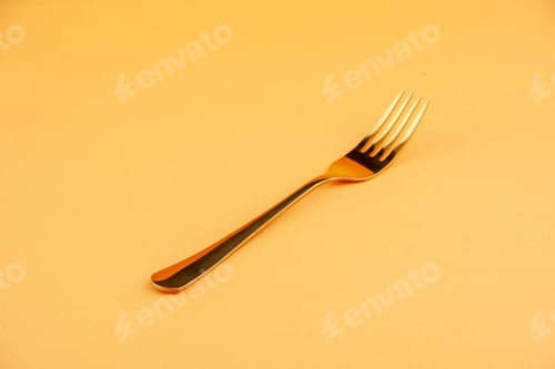 Preview: Front view of elegant shiny golden stainless spoon on isolated yellow background with free space