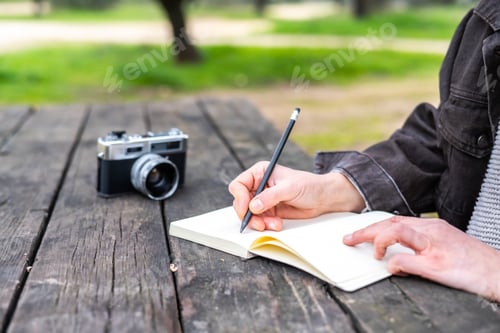 Preview: Analog photography and creative process concept with photographer journaling outdoors