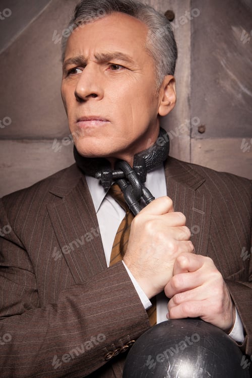 Preview: Chains on his neck. Grey hair senior man in formalwear trying to take off the chain from his neck