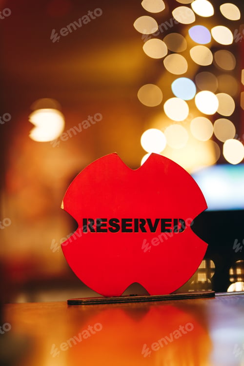 Preview: Red Reserved Sign On Wooden Table With Bokeh Background