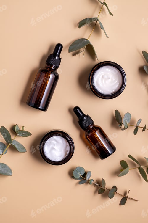 Preview: Brown glass bottles and eucalyptus branches on beige background. Eco-friendly organic natural cosmet