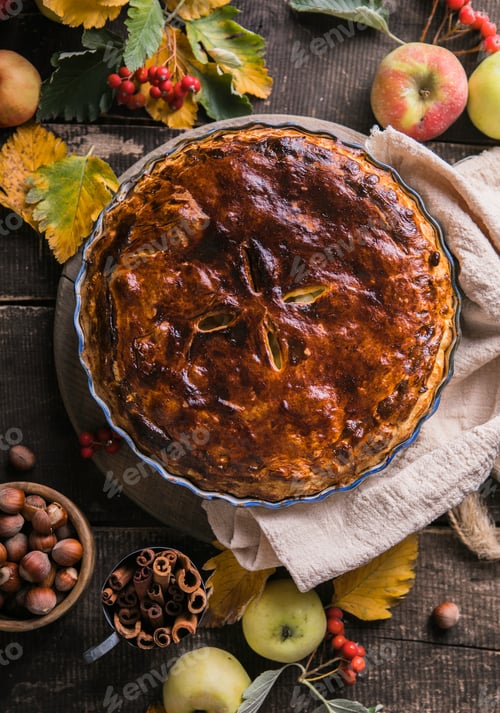 Preview: Homemade apple pie surrounded by fresh fruits, nuts, apples