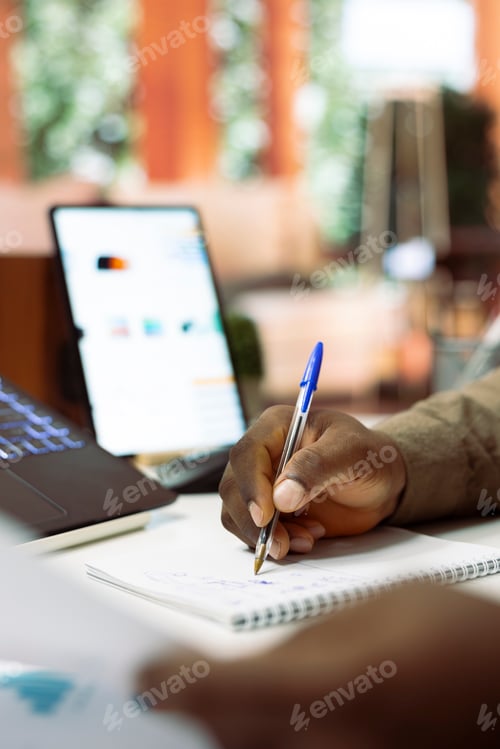Preview: Business owner writes monthly accounting balance numbers on a notebook
