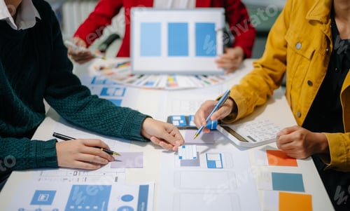 Preview: Close up view of UI developer team brainstorming on their project with laptop, smartphone