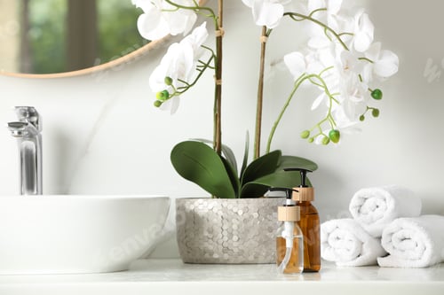 Preview: Bottles with dispenser caps, houseplant and towels on white table in bathroom