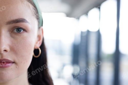 Preview: In modern office, young Caucasian female wearing green headband standing, copy space