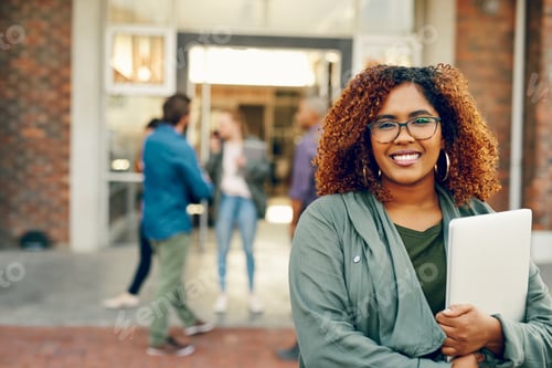 Preview: Portrait of a happy young woman holding a laptop outdoors on campus
