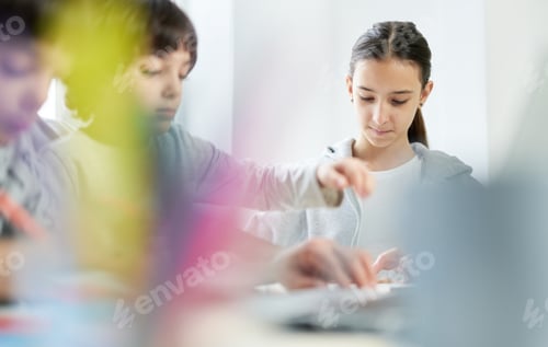 Preview: Focused teenage latin girl spending time with her little brothers at home