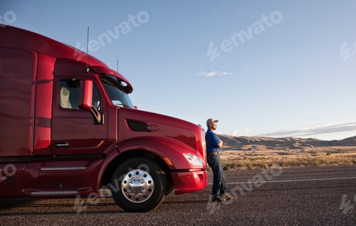 Preview: Truck driver leaning on the grill of his commercial truck.