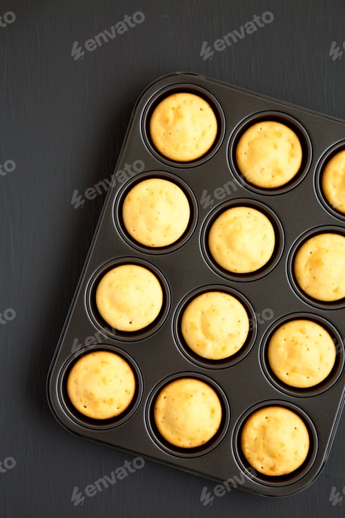 Preview: Homemade Cornbread Muffins on a black background, top view. Flat lay, overhead, from above.