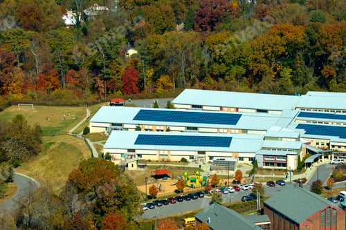 Preview: Aerial view of american school building with rooftop covered with photovoltaic solar panels