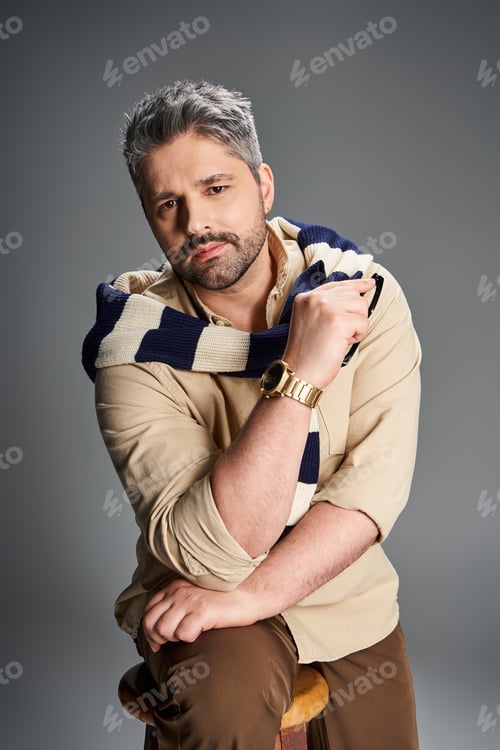 Preview: Stylish man with bristle posing confidently in modern studio setting during daytime