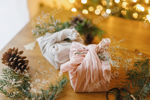 Preview: Stylish zero waste gifts on rustic table on background of christmas tree with lights