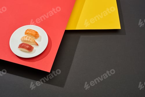 Preview: fresh nigiri with salmon, shrimp and tuna on red, yellow and black surface