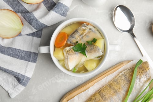 Preview: Delicious fish soup served on light table, flat lay