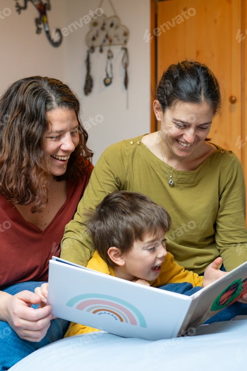 Preview: Child with his two lesbian mothers watching a photo album at home. LGBTQIA Family