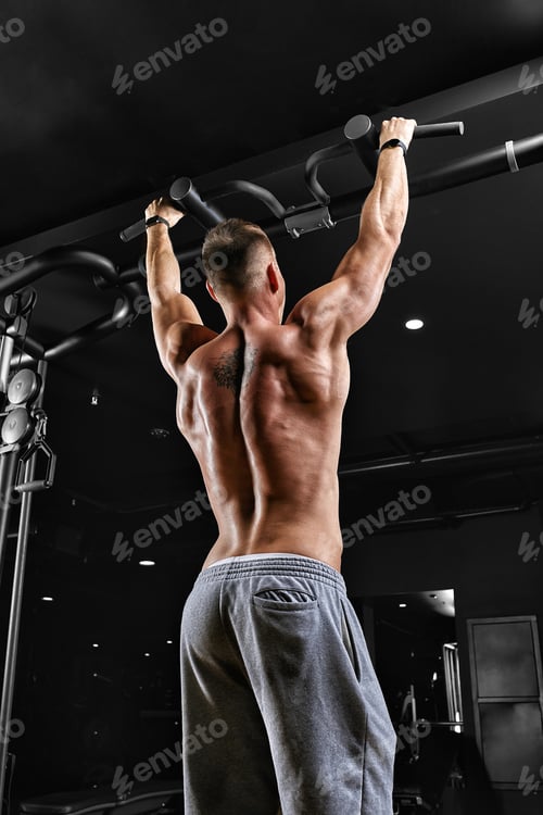 Preview: A man does pull-ups on the horizontal bar gym, a dark background, a beautiful body, Fitness