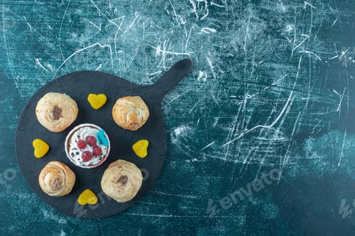 Preview: A dark board with sweet pastries on a blue background