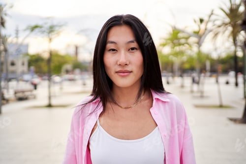 Preview: Portrait of Asian woman looking at camera carefree, standing outdoors in a beach city for holidays.