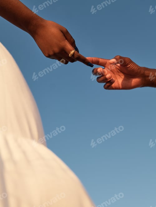 Preview: Unrecognizable black expecting mother and anonymous male touching index fingers