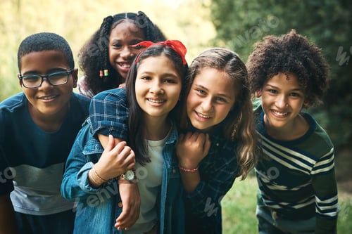 Preview: Shot of a group of teenagers embracing in nature at summer camp