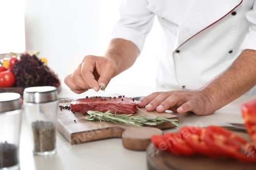 Preview: Professional chef cooking meat on table in kitchen, closeup