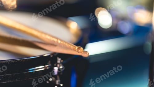 Preview: Close-up, snare drum and drumsticks on a dark background.