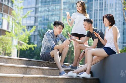 Preview: Happy young adults using smart phone together