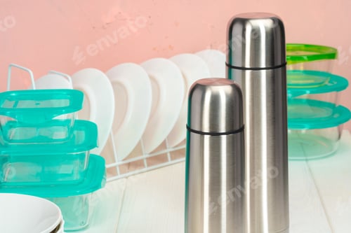Preview: Thermos bottle against tableware in a kitchen