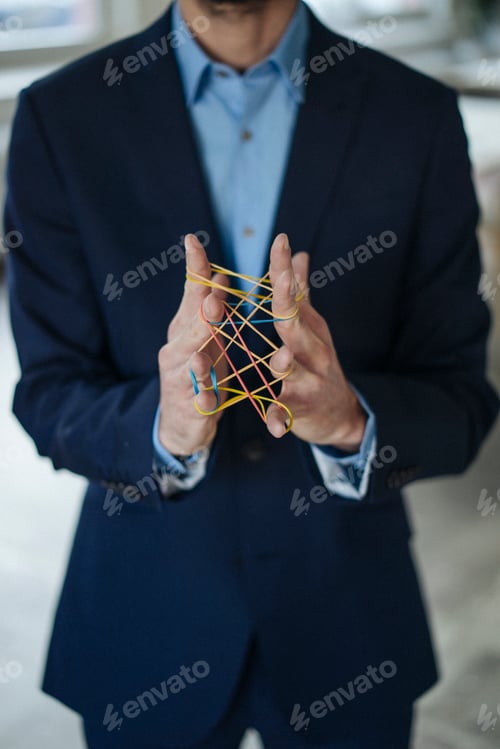 Preview: Close-up of businessman holding rubber bands