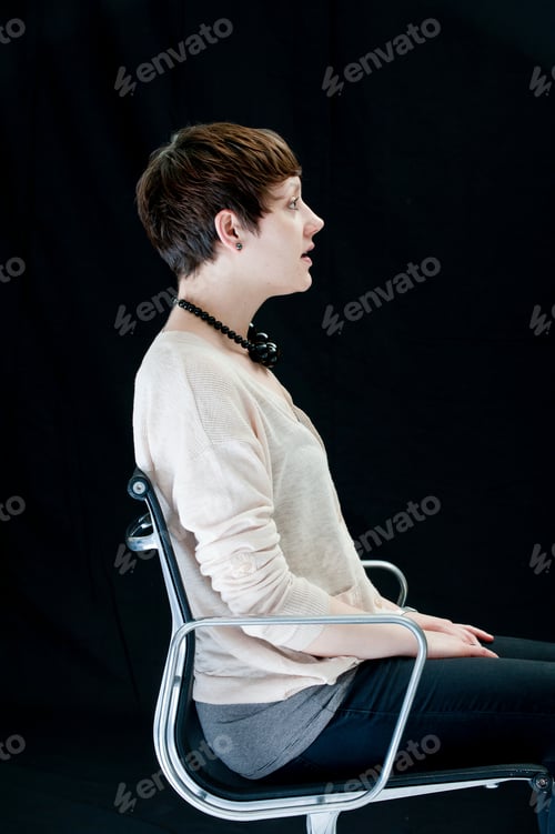 Preview: Pensive Woman with Short Hair Sits in Chair
