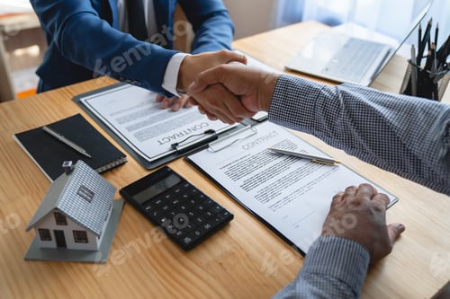 Preview: Young businessman and financial representative shaking hands after a budget deal for business expans