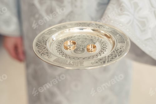 Preview: Close-up photo of a wedding ring held by a priest in a church before the wedding ceremony