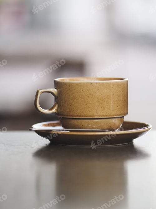 Preview: A ceramic cup with coffee stands on a concrete table in a summer cafe, no people.