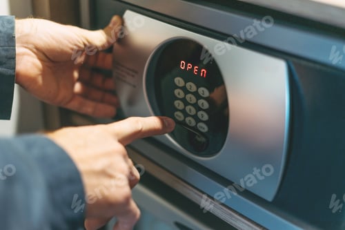 Preview: Adult man in blue jacket uses safe in the hotel room