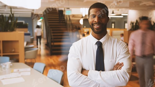 Preview: Portrait Of Businessman In Modern Office With Colleagues Meeting Around Table In Background