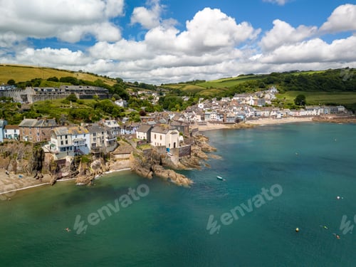 Preview: a coastal village with houses on cliffs and a clear blue sea in Cornwall, England