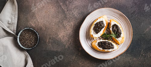 Preview: Delicious sandwiches with ricotta and black chia caviar on a plate on the table top view web banner