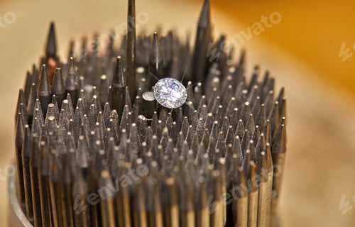 Preview: Jewelry production. The diamond is held with tweezers against the background